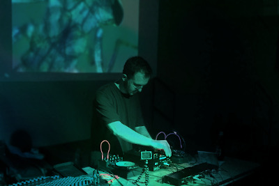 A glitch turntablism performance, washed in brightly coloured stage lights